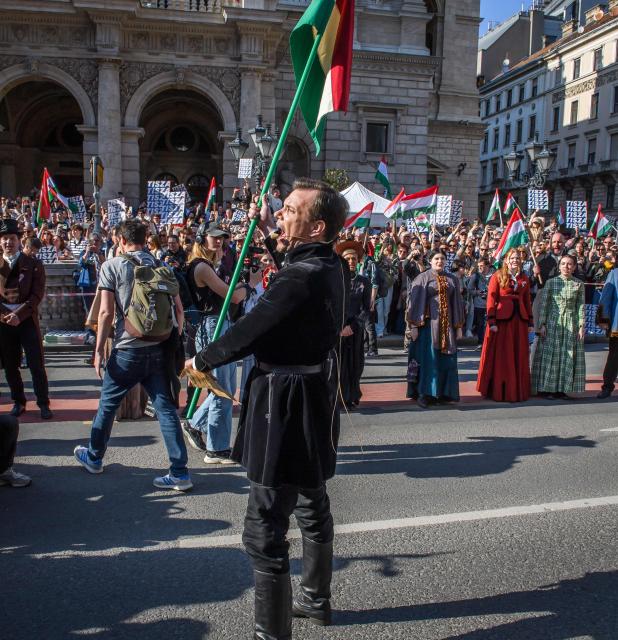 Hungarian opposition leader and president of the TISZA (Respect and Freedom) party Peter Magyar (C) raises a national flag of Hungary during a "National March” in Budapest, Hungary on March 15, 2026, on the 178th anniversary of the Hungarian Revolution and War of Independence of 1848-1849. The 1848-1849 revolution in the Kingdom of Hungary grew into a war for independence from the Austrian Empire, ruled by the Habsburg dynasty. (Photo by Ferenc ISZA / AFP)