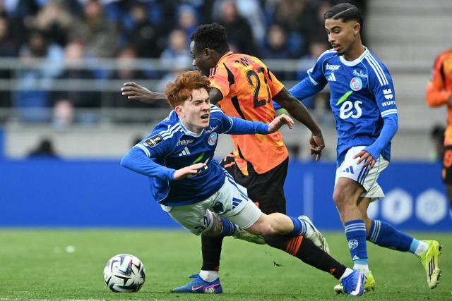 Strasbourg’s Argentine defender #32 Valentin Barco (L) fights for the ball with Paris Fc’s Nigerian forward #27 Moses Simon (C) during the French L1 football match between RC Strasbourg Alsace and Paris FC at the Stade de la Meinau in Strasbourg, eastern France on March 15, 2026. (Photo by SEBASTIEN BOZON / AFP)