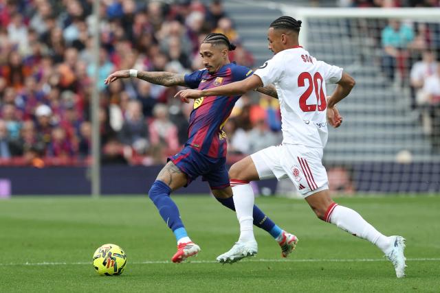 Barcelona's Brazilian forward #11 Raphinha (L) vies for the ball with Sevilla's Swiss midfielder #20 Djibril Sow during the Spanish League football match between FC Barcelona and Sevilla FC at the Camp Nou Stadium in Barcelona, on March 15, 2026. (Photo by Lluis GENE / AFP)