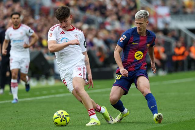 Sevilla's Spanish defender #36 Oso (L) vies for the balll with Barcelona's Spanish midfielder #20 Daniel Olmo during the Spanish League football match between FC Barcelona and Sevilla FC at the Camp Nou Stadium in Barcelona, on March 15, 2026. (Photo by Lluis GENE / AFP)