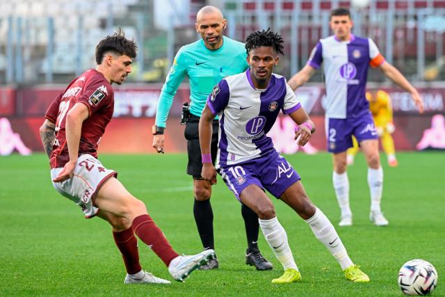 Metz's French midfielder #20 Jessy Deminguet (L) and Toulouse's French forward #10 Yann Gboho (C) fight for the ball during the French L1 football match between FC Metz and Toulouse FC at the Stade Saint-Symphorien in Longeville-les-Metz, eastern France, on March 15, 2026. (Photo by Jean-Christophe VERHAEGEN / AFP)