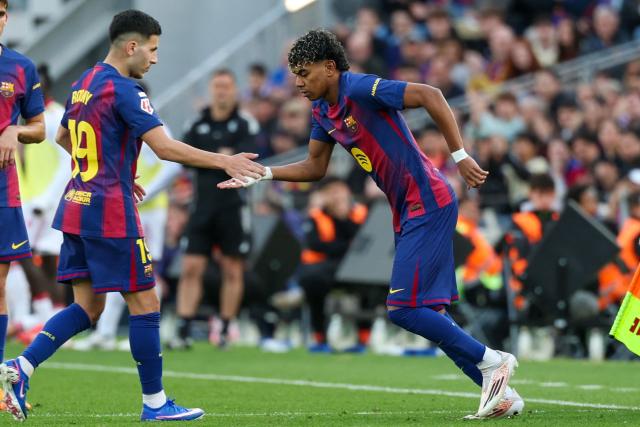 Barcelona's Spanish forward #10 Lamine Yamal (R) enters the pitch to substitue Barcelona's Swedish forward #19 Roony Bardghji during the Spanish League football match between FC Barcelona and Sevilla FC at the Camp Nou Stadium in Barcelona, on March 15, 2026. (Photo by Lluis GENE / AFP)