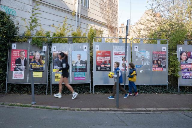 Pedestrians walk past campaign posters for the Lille mayoral candidates during the first round of France's 2026 municipal elections in Lille, northern France, on March 15, 2026. (Photo by Elise HOUBEN / AFP)