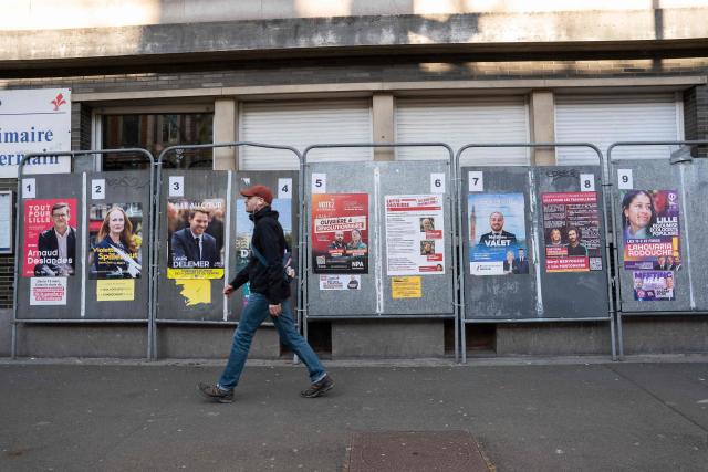 A pedestrian walks past campaign posters for the Lille mayoral candidates during the first round of France's 2026 municipal elections in Lille, northern France, on March 15, 2026. (Photo by Elise HOUBEN / AFP)