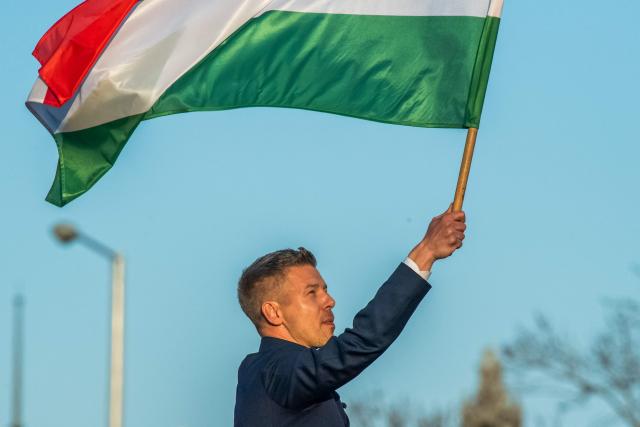 Hungarian opposition leader and president of the Tisza (Respect and Freedom) party Peter Magyar waves a Hungarian flag during a campaign rally organised by Hungary's Tisza party in Budapest, on Hungary’s national holiday, March 15, 2026. The 1848-1849 revolution in the Kingdom of Hungary grew into a war for independence from the Austrian Empire, ruled by the Habsburg dynasty. (Photo by Ferenc ISZA / AFP)