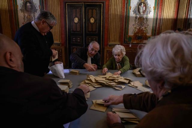 Officials process materials following the closing of voting during municipal elections at the city hall in Perpignan, south-western France, on March 15, 2026. (Photo by Ed JONES / AFP)