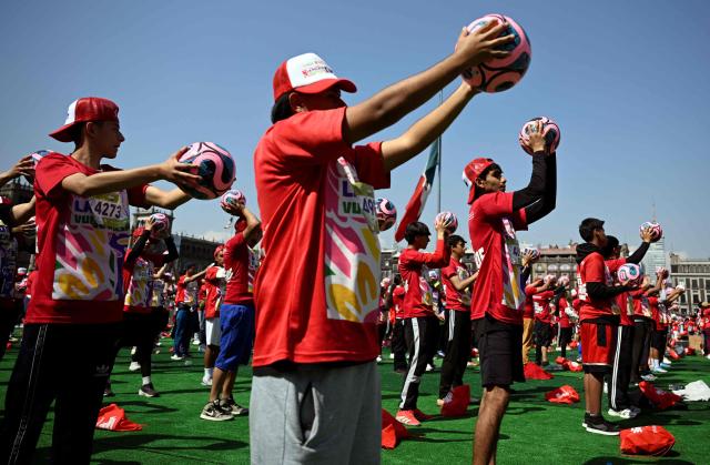 People take part in a world-class football clinic at the Zocalo square in Mexico City on March 15, 2026, aimed at setting a new Guinness World Record. (Photo by Alfredo ESTRELLA / AFP)