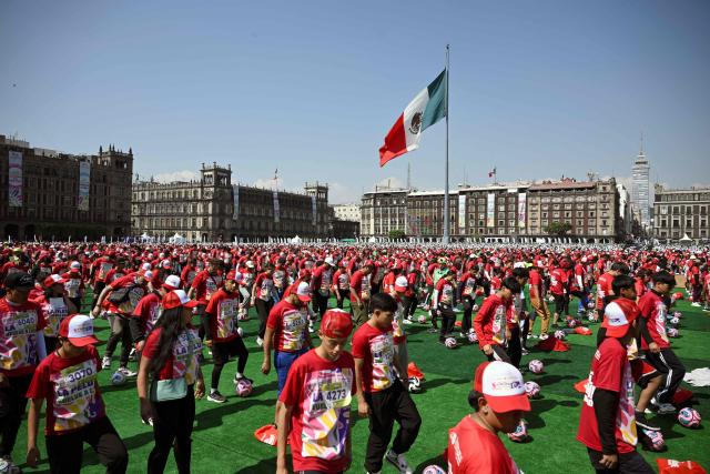People take part in a world-class football clinic at the Zocalo square in Mexico City on March 15, 2026, aimed at setting a new Guinness World Record. (Photo by Alfredo ESTRELLA / AFP)