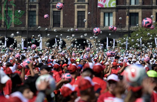 Hundreds of people take part in a world-class football clinic at the Zocalo square in Mexico City on March 15, 2026, aimed at setting a new Guinness World Record. (Photo by Alfredo ESTRELLA / AFP)