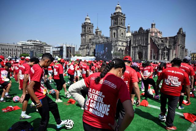 People take part in a world-class football clinic at the Zocalo square in Mexico City on March 15, 2026, aimed at setting a new Guinness World Record. (Photo by Alfredo ESTRELLA / AFP)