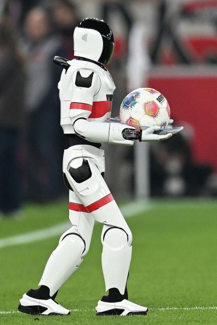A robot carries the match ball on to the pitch prior to the German first division Bundesliga football match between VfB Stuttgart and RB Leipzig in Stuttgart, southern Germany, on March 15, 2026. (Photo by THOMAS KIENZLE / AFP) / DFL REGULATIONS PROHIBIT ANY USE OF PHOTOGRAPHS AS IMAGE SEQUENCES AND/OR QUASI-VIDEO  ALTERNATIVE CROP