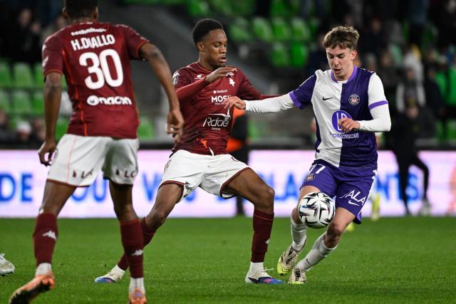 Toulouse's Argentine forward #07 Julian Vignolo (R) and Metz's French forward #19 Lucas Michal (C) fight for the ball during the French L1 football match between FC Metz and Toulouse FC at the Stade Saint-Symphorien in Longeville-les-Metz, eastern France, on March 15, 2026. (Photo by Jean-Christophe VERHAEGEN / AFP)
