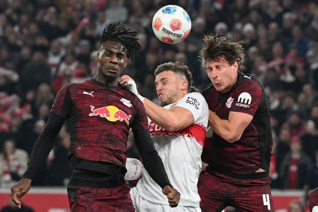 (L-R) Leipzig's French defender #23 Castello Lukeba, Stuttgart's Bosnian forward #09 Ermedin Demirovic and Leipzig's Hungarian defender #04 Willi Orban jump to head the ball during the German first division Bundesliga football match between VfB Stuttgart and RB Leipzig in Stuttgart, southern Germany, on March 15, 2026. (Photo by THOMAS KIENZLE / AFP) / DFL REGULATIONS PROHIBIT ANY USE OF PHOTOGRAPHS AS IMAGE SEQUENCES AND/OR QUASI-VIDEO
