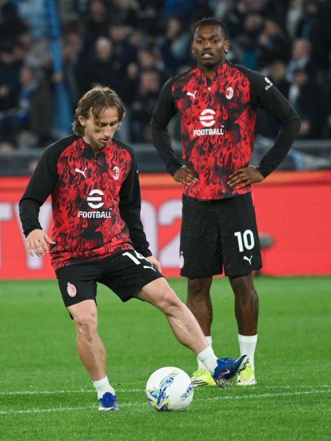 AC Milan's Portuguese forward #10 Rafael Leao (R) looks at AC Milan's Croatian midfielder #14 Luka Modric warm up before the start of the Italian Serie A football match between Lazio and AC Milan at Olympic stadium in Rome on March 15, 2026. (Photo by Alberto PIZZOLI / AFP)