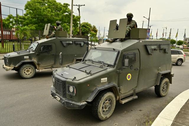 Ecuadorean soldiers cross the Carlos Perez Perasso Puente de la Unidad Nacional (National Unity Bridge) on their way to Duran, Guayas province, Ecuador on March 15, 2026, during preparations for a two-week operation, starting later today, to crack down on drug trafficking gangs with U.S. support and under strict curfews in the most violent regions. (Photo by MARCOS PIN / AFP)