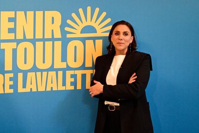 Toulons far-right Rassemblement National (RN) party mayoral candidate, Laure Lavalette poses in front of a campaign poster at her campaign headquarters after the first results of the first round of France's 2026 municipal elections in Toulon, southern France, on March 15, 2026. Lavalette has emerged as the frontrunner in the first round of the municipal elections in Toulon, with between 39.4% and 42% of the vote according to estimates, ahead of the outgoing mayor in a city where the left will not be contesting the second round. (Photo by Miguel MEDINA / AFP)