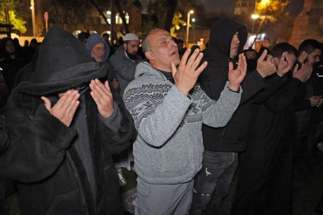 Palestinian Muslims pray outside the Old City of Jerusalem on Laylat al-Qadr or Night of Destiny, one of the holiest nights during the holy fasting month of Ramadan on March 15, 2026, as the nearby al-Aqsa Mosque remains closed following the outbreak of the US-Israel war with Iran on February 28. Israel has shut all holy sites in east Jerusalem's Old City for security reasons after it began airstrikes with the United States against Iran that have sparked a regional war. (Photo by AHMAD GHARABLI / AFP)
