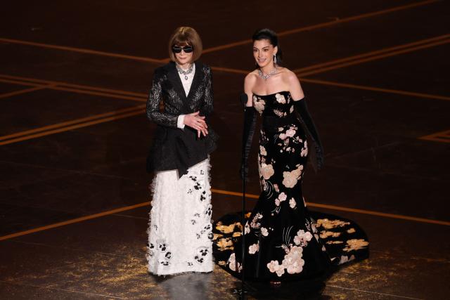 British-US fashion editor Anna Wintour and US actress Anne Hathaway present the Oscar for Best Costume Design onstage during the 98th Annual Academy Awards at the Dolby Theatre in Hollywood, California on March 15, 2026. (Photo by Patrick T. Fallon / AFP)