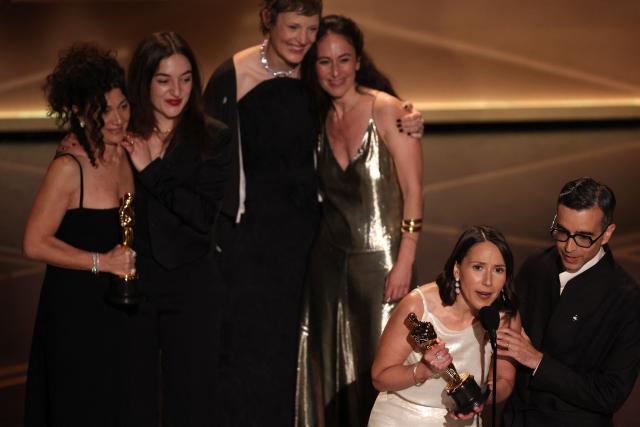 US curator Natalie Musteata and US filmmaker Alexandre Singh accept the Oscar for Best Live Action Short Film for "Two People Exchanging Saliva" onstage during the 98th Annual Academy Awards at the Dolby Theatre in Hollywood, California on March 15, 2026. (Photo by Patrick T. Fallon / AFP)