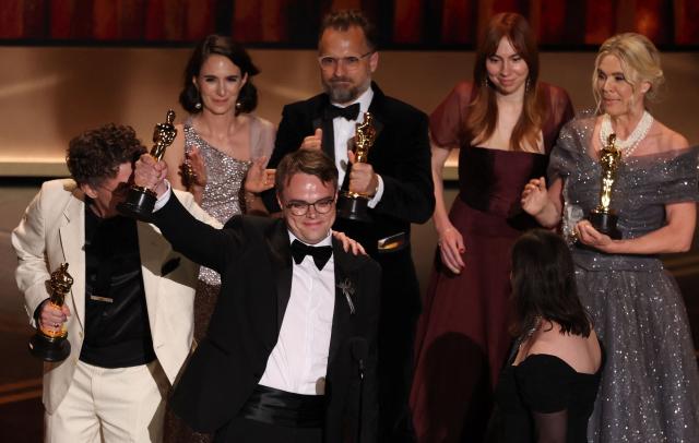 Russian teacher Pavel Talankin (2L) stands alongside US documentary filmmaker David Borenstein (L) as he accepts the award for Best Documentary Feature Film for "Mr. Nobody Against Putin" onstage during the 98th Annual Academy Awards at the Dolby Theatre in Hollywood, California on March 15, 2026. (Photo by Patrick T. Fallon / AFP)