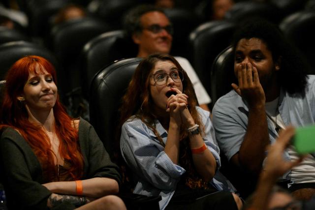 People react as they watch the live broadcast of the 98th Annual Academy Awards (Oscars) inside the Estacao Botafogo cinema in the Botafogo neighborhood in Rio de Janeiro, Brazil on March 15, 2026. Brazilians all over the country are gathered expecting the result of the nominations of the Brazilian film "O Agente Secreto" (The Secret Agent). (Photo by Mauro PIMENTEL / AFP)
