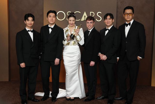 (L/R) Yu Han Lee, Jeong Hoon Seo, South Korean-US singer Ejae, US songwriter Mark Sonnenblick, Hee Dong Nam pose in the press room with the Oscar for Best Music (Original Song) for "Golden" from "KPop Demon Hunters" during the 98th Annual Academy Awards at the Dolby Theatre in Hollywood, California on March 15, 2026. (Photo by VALERIE MACON / AFP)