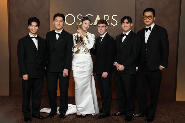 (L/R) Yu Han Lee, Jeong Hoon Seo, South Korean-US singer Ejae, US songwriter Mark Sonnenblick, Hee Dong Nam pose in the press room with the Oscar for Best Music (Original Song) for "Golden" from "KPop Demon Hunters" during the 98th Annual Academy Awards at the Dolby Theatre in Hollywood, California on March 15, 2026. (Photo by VALERIE MACON / AFP)