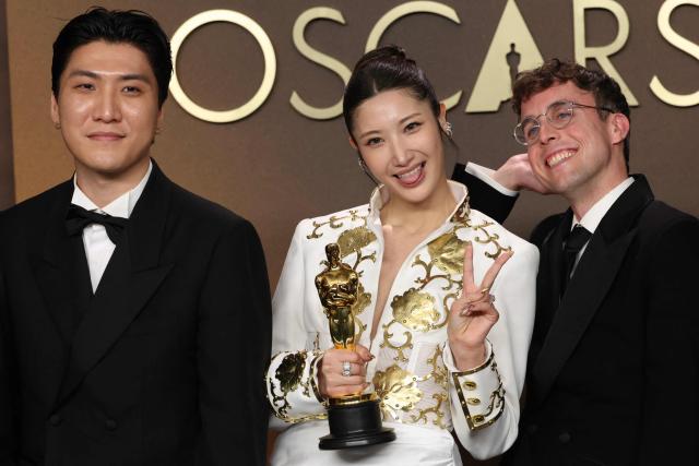 (L/R) Jeong Hoon Seo, South Korean-US singer Ejae, US songwriter Mark Sonnenblick pose in the press room with the Oscar for Best Music (Original Song) for "Golden" from "KPop Demon Hunters" during the 98th Annual Academy Awards at the Dolby Theatre in Hollywood, California on March 15, 2026. (Photo by VALERIE MACON / AFP)