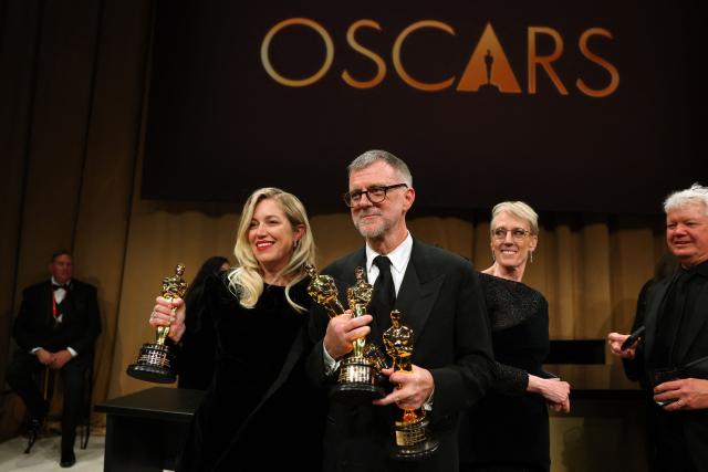US director Paul Thomas Anderson stands with his Oscars for Best Picture, Best Adapted Screenplay and Best Director for "One Battle After Another"  next to US producer Sara Murphy with her Oscar for Best Picture for "One Battle After Another" during the 98th Annual Academy Awards Governors Ball at the Dolby Theatre in Hollywood, California on March 15, 2026. (Photo by ANGELA WEISS / AFP)