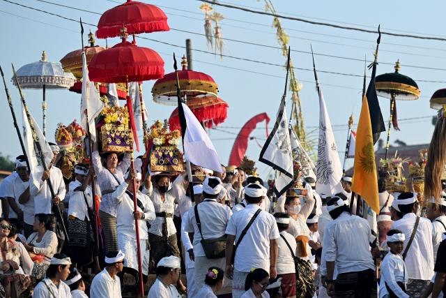 Hindu devotees take part in a Melasti ceremony prayer at a beach in Denpasar on Indonesia's resort island of Bali on March 16, 2026. Melasti is a purification festival which is held several days before "Nyepi", the day of silence, when Hindu devotees are not allowed to work, travel or take part in any indulgence (Photo by SONNY TUMBELAKA / AFP)