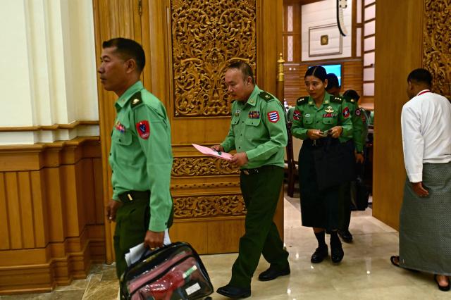 Military officers who serve as members of Myanmar's parliament leave after a session of the third term of the Pyithu Hluttaw (House of Representatives) in Naypyidaw on March 16, 2026. Myanmar parliament convened on March 16 for the first time since a 2021 military coup, AFP journalists saw, packed with pro-junta lawmakers elected in a poll choreographed by the top brass. (Photo by Sai Aung MAIN / AFP)