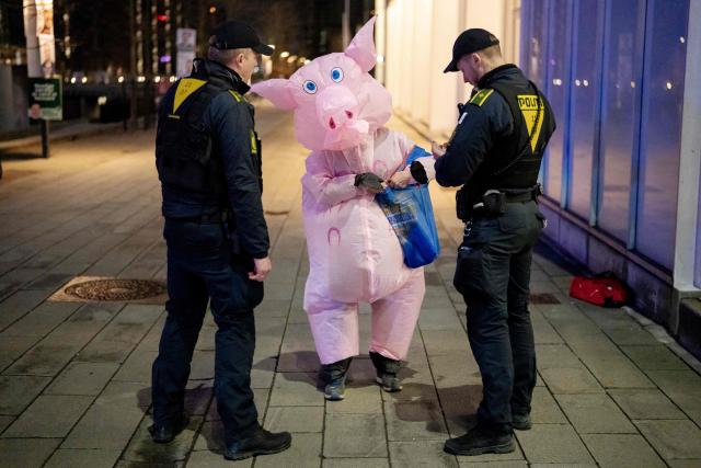 A person wearing a pig costume talks to police during the debate "Face to Face - Who should lead Denmark?" hosted by Kaare Quist in DR Byen in Copenhagen, Denmark on March 15, 2026. The Danish parliamentary election will be held on March 24, 2026. (Photo by Mads Claus Rasmussen / Ritzau Scanpix / AFP) / Denmark OUT