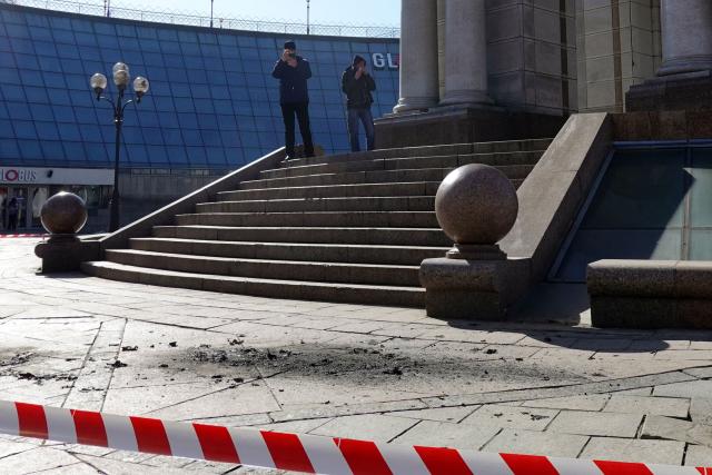 Pedestrians visit the crash site of drone fragments on Independence Square in Kyiv on March 16, 2026, amid the Russian invasion of Ukraine. Explosions rang out over the Ukrainian capital on March 16, 2026 and AFP journalists witnessed air defence batteries fending off a barrage of Russian projectiles during a rare daytime attack on Kyiv. (Photo by Maryke VERMAAK / AFP)