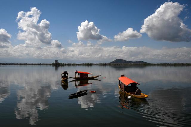 Kashmiri boatmen row their shikara boats in Dal Lake in Srinagar on March 16, 2026. (Photo by Tauseef MUSTAFA / AFP)