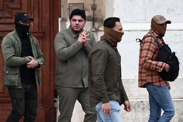 Escorted French anti-drug activist and electoral candidate Amine Kessaci (C) leaves after Marseille's incumbent mayor and broad left-wing coalition "Printemps Marseillais" candidate for re-election Benoit Payan (unseen) submitted a list, the day following the first round of France's 2026 municipal elections at the prefecture in Marseille, southern France, on March 16, 2026. Benoоt Payan, wants no backroom deals and is going it alone in the second round, calling on “everyone to take responsibility” in the face of the National Rally, which is “at Marseille’s doorstep,” putting both LFI and the right under pressure. (Photo by Thibaud MORITZ / AFP)