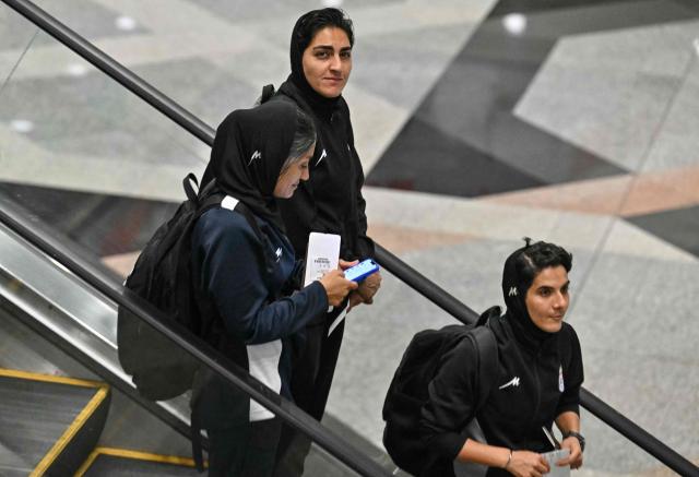 Iranian women's football team captain Zahra Ghanbari (C) and other members of her team are seen at the Kuala Lumpur International Airport in Sepang on March 16, 2026, after staying in a hotel in the Malaysian capital while awaiting the next leg of their journey home. Three more members of the Iranian women's football team have left their asylum in Australia and decided to return home, Canberra said on March 15. (Photo by MOHD RASFAN / AFP)
