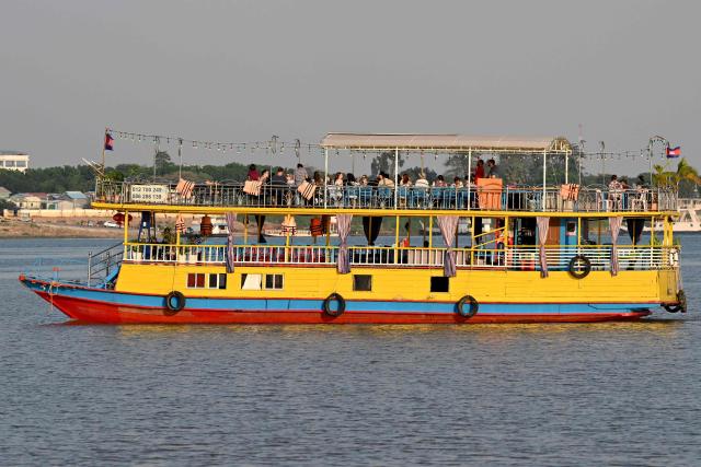 Tourists sit on a tourist boat as they travel along the Mekong River in Phnom Penh on March 16, 2026. (Photo by TANG CHHIN Sothy / AFP)