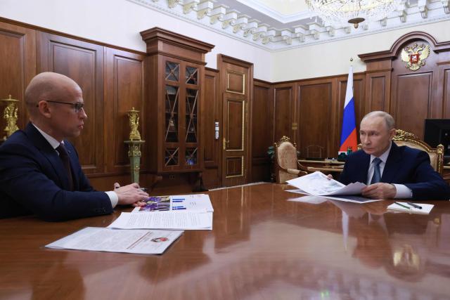 In this pool photograph distributed by the Russian state agency Sputnik, Russia's President Vladimir Putin (R) attends a meeting with Head of the Udmurt Republic Alexander Brechalov (L) in Moscow on March 16, 2026. (Photo by Gavriil GRIGOROV / POOL / AFP)