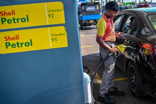 An employee fills petrol in a car at a filling station in Wellawatte on the outskirts of Colombo on March 16, 2026. (Photo by Ishara S. KODIKARA / AFP)