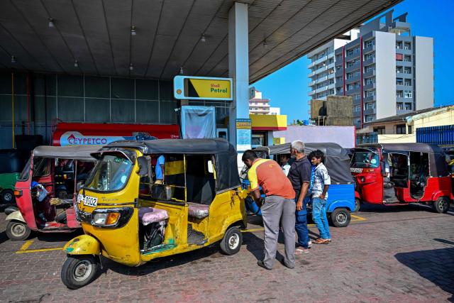 An employee fills petrol in an autorickshaw at a filling station in Wellawatte on the outskirts of Colombo on March 16, 2026. (Photo by Ishara S. KODIKARA / AFP)