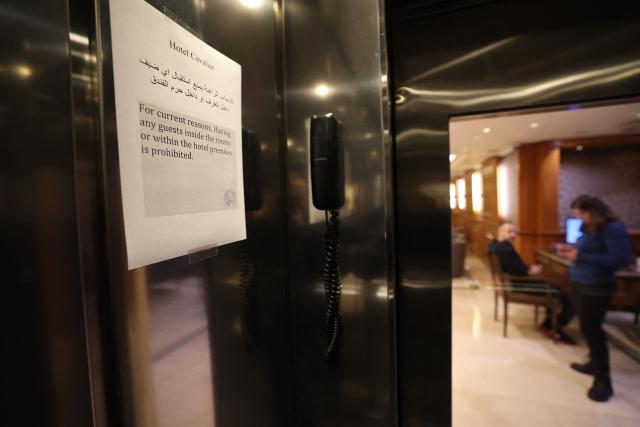A printed notice taped near the elevator doors of a hotel informs clients that guests are forbidden from visiting the hotel due to the war situation in Beirut on March 16, 2026. On February 28, Israel and the United States launched strikes on Iran, killing its supreme leader and triggering a war that spread across the Middle East, with Lebanon's Hezbollah entering the fray. Lebanon's health ministry said on March 14, that Israeli strikes have killed 850 people, including 66 women and 107 children, since the start of the war with Hezbollah, adding that 2,105 others were wounded. (Photo by Anwar AMRO / AFP)