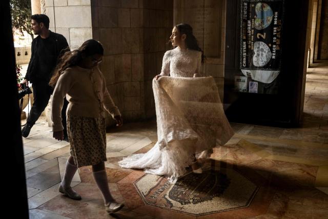 Wedding guests make their way into a bomb shelter after sirens wailed of an impending projectile attack in Jerusalem on March 16, 2026. On February 28, Israel and the United States launched strikes on Iran, killing its supreme leader Ayatollah and triggering a war that spread across the Middle East. (Photo by JOHN WESSELS / AFP)