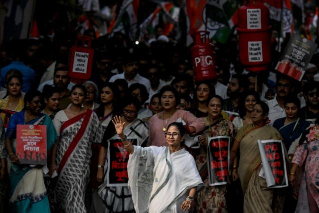 Chief Minister of West Bengal State Mamata Banerjee (C) along with Trinamool Congress (TMC) party supporters walks a rally to protest against the price hike and shortage of liquid petroleum gas (LPG) in Kolkata on March 16, 2026 as the Middle East war disrupts supply chains. (Photo by Dibyangshu SARKAR / AFP)