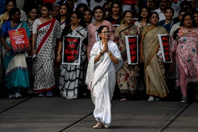 Chief Minister of West Bengal State Mamata Banerjee (C) along with Trinamool Congress (TMC) party supporters walks a rally to protest against the price hike and shortage of liquid petroleum gas (LPG) in Kolkata on March 16, 2026 as the Middle East war disrupts supply chains. (Photo by Dibyangshu SARKAR / AFP)