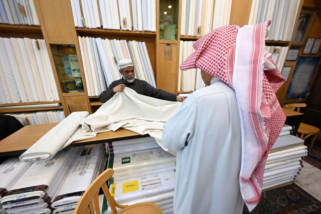 A Kuwaiti man shops for fabrics at a textile store in a traditional market in Kuwait City on March 16, 2026, ahead of Eid al-Fitr, the holiday marking the end of the Muslim holy fasting month of Ramadan. (Photo by YASSER AL-ZAYYAT / AFP)