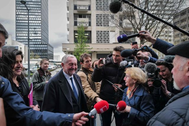 Lyon's mayoral candidate, whose list is supported by right-wing Les Republicains (LR) party and centrist party Renaissance, Jean-Michel Aulas (L) speaks to inhabitants surrounded by journalists as part of his campaign for the second round of France's 2026 local elections in Lyon, central-eastern France, on March 16, 2026. Long considered the frontrunner in the polls for the Lyon mayoral election, the former Olympique Lyonnais President said he was "disappointed" on March 15, 2026 to find himself neck and neck with Green Party mayor in the first round, ahead of the La France Insoumise (LFI) candidate in third. (Photo by OLIVIER CHASSIGNOLE / AFP)