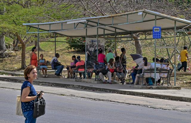 People wait at a bus stop in Havana during a blackout on March 16, 2026.energy saving. Cuba suffered a widespread power cut on March 16, 2026, according to the national electricity company, against the backdrop of a severe crisis on the island caused by the US energy blockade. (Photo by ADALBERTO ROQUE / AFP)