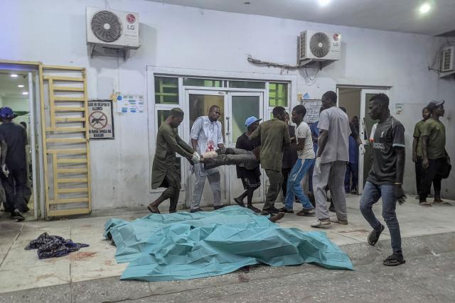 TOPSHOT - People carry an injured man past bodies covered with sheets at a hospital in Maiduguri on March 16, 2026 following blasts in the city. Multiple explosions rocked the northeastern Nigerian city of Maiduguri in the evening of March 16, 2026, government and healthcare sources told AFP, on the back of an overnight attack on a military post.
Earlier, suspected jihadists launched an attack on a Nigerian military post on the outskirts of Maiduguri, a key northeastern city that had not seen such violence in years. (Photo by AFP)