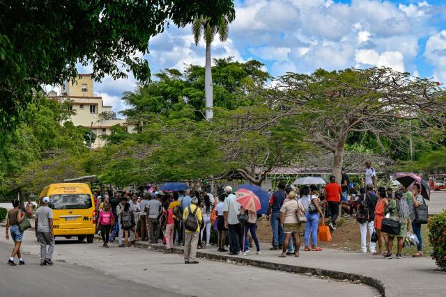 People wait at a bus stop in Havana during a blackout on March 16, 2026. Cuba suffered a widespread power cut on March 16, 2026, according to the national electricity company, against the backdrop of a severe crisis on the island caused by the US energy blockade. (Photo by ADALBERTO ROQUE / AFP)