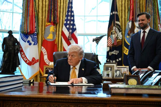 US President Donald Trump signs an executive order on fraud in the Oval Office at the White House in Washington, DC, on March 16, 2026 as Vice President JD Vance looks on. (Photo by ANNABELLE GORDON / AFP)